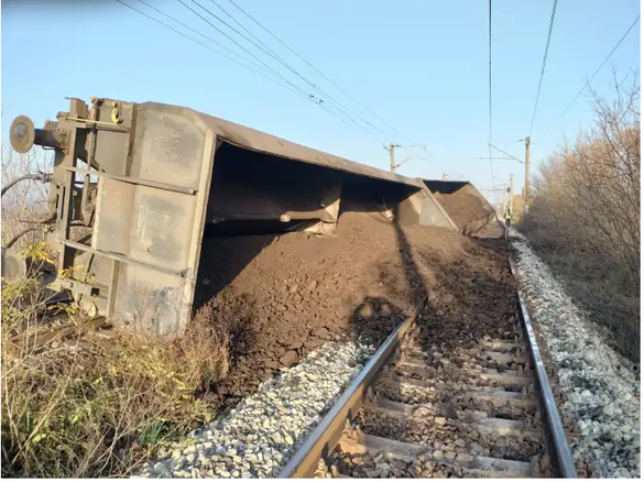 FOTO Nouă vagoane ale unui tren de marfă care transporta cărbune au deraiat, multe sunt răsturnate