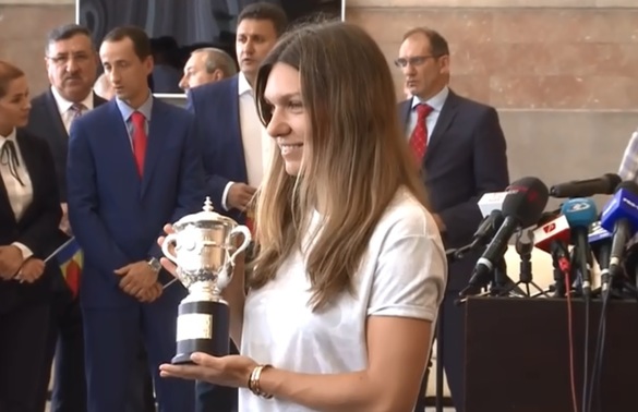 FOTO Halep a ajuns la București după câștigarea Roland Garros, prezentând o replică a trofeului la aeroport, după selfie-uri cu piloții în carlingă