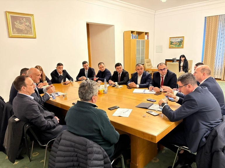 Deputatul Ionel Bogdan discutând cu membri ai PNL despre eliminarea impozitului minim cifra afaceri în coaliția guvernamentală la o întâlnire oficială. | sursa foto: News.ro