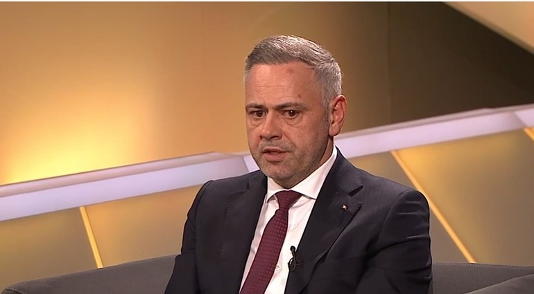 Câmp agricol vast din România cu teren arabil România arendat de companii străine, cu utilaje agricole în lucru sub cer senin. | sursa foto: News.ro