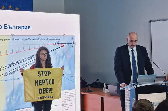 O activistă Greenpeace afișează un banner de protest față de Neptun Deep, în timpul prezentării proiectului de către reprezentantul OMV Petrom. Sursă foto: Greenpeace Bulgaria