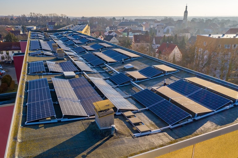 Panou solar și turbine eoliene în funcțiune sub cer senin, ilustrând producția energie regenerabilă moderată și impactul import energie ieftină asupra preț energie negativ în România. | sursa foto: Profit