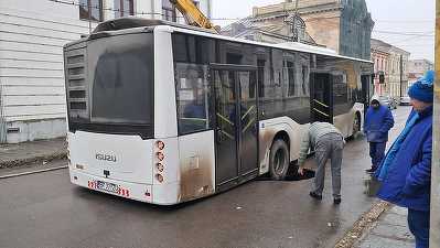 Autobuz cu pasageri, blocat într-o groapă în asfalt VIDEO&FOTO
