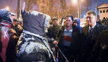 FOTO Iohannis a ieșit din Palatul Cotroceni pentru a discuta cu persoanele care protestau, în ninsoare, împotriva sa, retrăgându-se însă după 3 minute