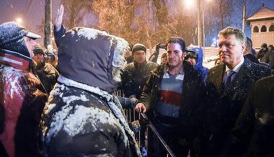 FOTO Iohannis a ieșit din Palatul Cotroceni pentru a discuta cu persoanele care protestau, în ninsoare, împotriva sa, retrăgându-se însă după 3 minute