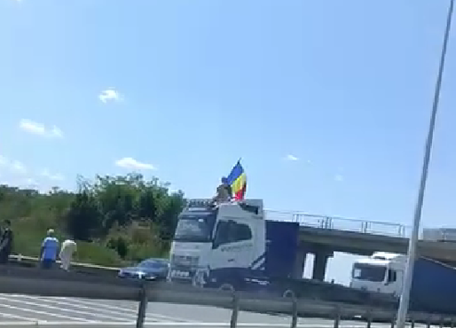 Protest pe sensul către București al A1 – Un șofer a oprit vehiculul de mare tonaj de-a latul șoselei și s-a urcat pe cabină, fluturând steagul României