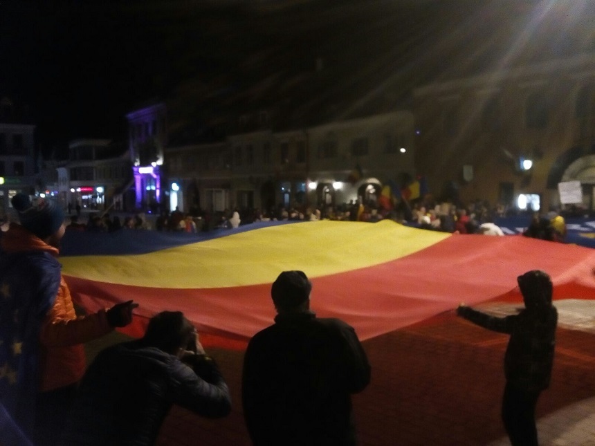 Drapele uriaşe în Piaţa Sfatului din Braşov, unde 200 de oameni au ieşit în stradă pentru a sărbători abrogarea Ordonanţei 13