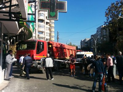 UPDATE - Accident grav în Capitală: O autobasculantă a lovit trei autoturisme, apoi a intrat pe trotuar şi s-a oprit lângă vitrina unei farmacii. FOTO