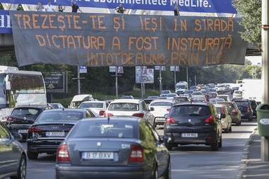 Câţiva protestatari au încercat să amplaseze în Piaţa Victoriei un banner cu mesajul "Trezeşte-te şi ieşi în stradă! Dictatura a fost instaurată întotdeauna prin lege" - FOTO