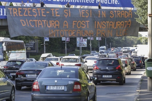 Câţiva protestatari au încercat să amplaseze în Piaţa Victoriei un banner cu mesajul "Trezeşte-te şi ieşi în stradă! Dictatura a fost instaurată întotdeauna prin lege" - FOTO