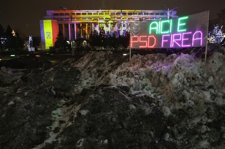 Protestatarul Cristian Dide a amplasat o pancartă luminoasă pe grămada de zăpadă depozitată în Piaţa Victoriei: "Aici e PSD Firea" - FOTO