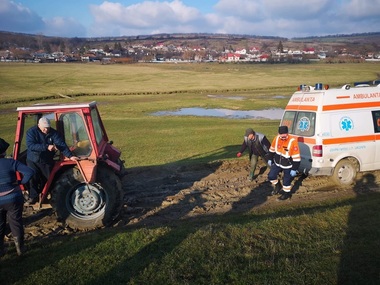 Vaslui: O ambulanţă care intervenea la o pacientă infectată cu SARS-CoV-2 a rămas blocată în noroi. Autospeciala a fost tractată de un tractor trimis de primărie - FOTO