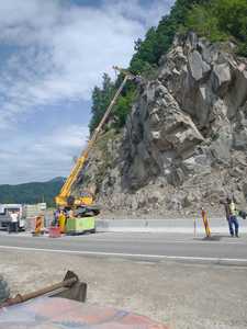 Lucrările de punere în siguranţă a versantului pe marginea DN 10 continuă - s-au montat ancore şi stâlpi de susţinere, urmând a fi instalate plase de retenţie - FOTO