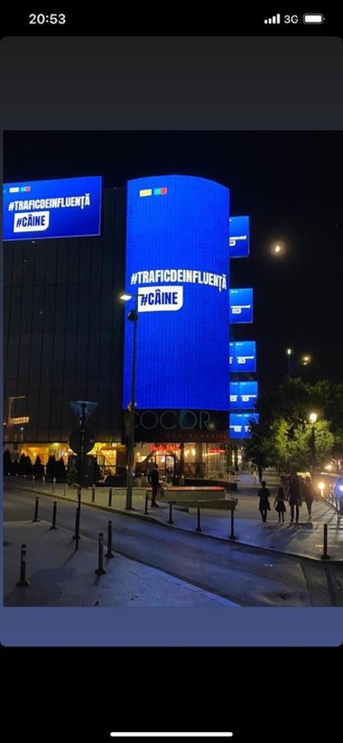 Panou luminos pe care scrie ”trafic de influenţă” şi ”Câine”, aluzie la acuzaţiile aduse lui Nicuşor Dan în campanie, pe magazinul Cocor, chiar vizavi de sediul de campanie al candidatului PNL-USR PLUS / Ciucu:Ce mizerie ilegală! Firea, noaptea ca hoţii