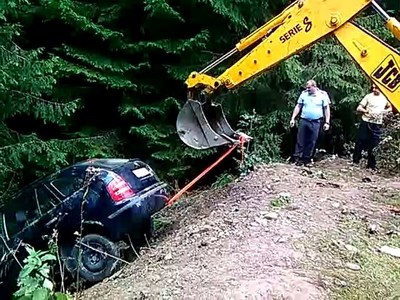 Dâmboviţa: Patru turişti au căzut cu maşina într-o râpă de zece metri; jandarmii au scos autoturismul cu un buldoexcavator. FOTO, VIDEO