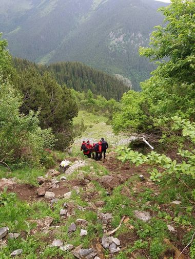 Un bărbat care participa la o cursă în Munţii Retezat s-a accidentat, fiind transportat peste o oră prin munte de salvamontişti şi jandarmi - VIDEO