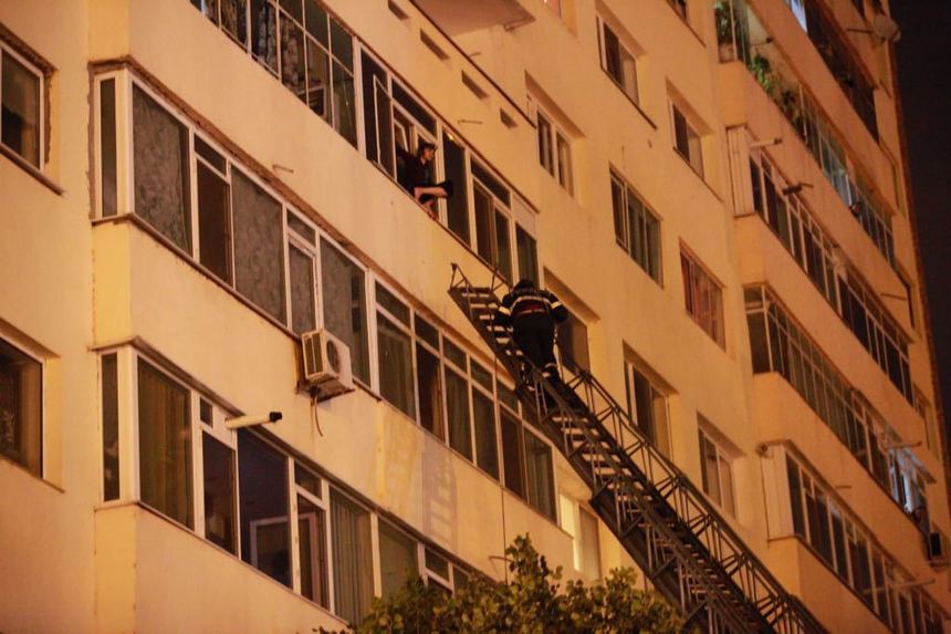 O femeie stă agăţată de un balcon situat la etajul al cincilea al unui bloc turn din Buzău şi ameninţă că se aruncă în gol