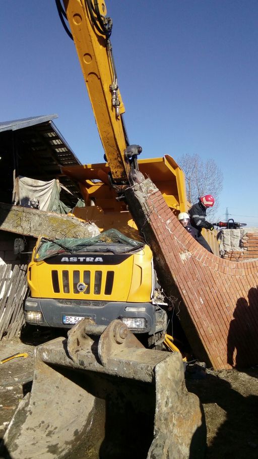 Argeş: Şofer de basculantă, grav rănit după ce a acroşat o poartă de cărămidă care a căzut peste cabină