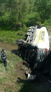 Braşov: Un autocamion încărcat cu ciment s-a răsturnat într-un pârâu; şoferul a fost rănit - FOTO