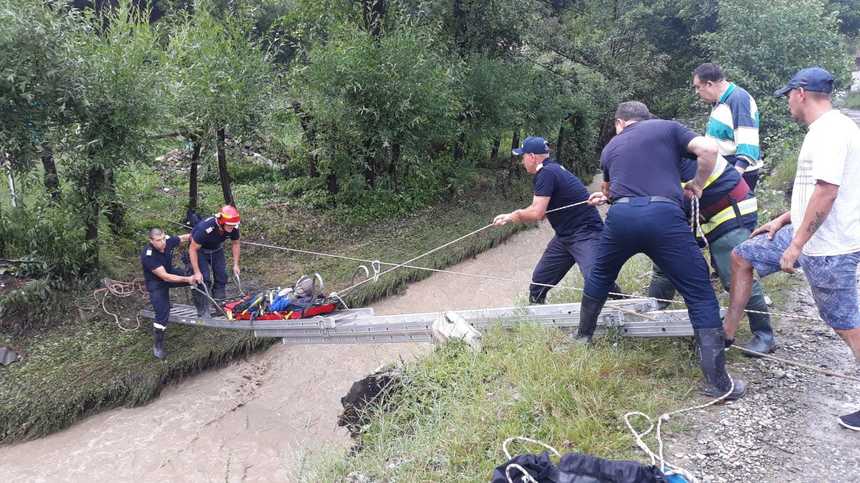 Neamţ: Mai mulţi copaci au căzut peste o casă în care locuieşte o femeie de 89 de ani/ Aceasta a fost salvată de pompieri, podeţul de acces fiind şi el distrus - FOTO