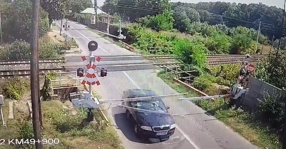 Şofer filmat în timp ce forţează şi rupe bariera chiar înainte de trecerea la nivel cu calea ferată, în Brazi, judeţul Prahova - FOTO

