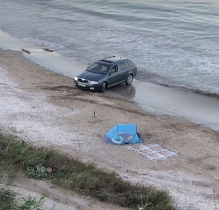 UPDATE - Maşină împotmolită în nisip, pe o plajă din localitatea 23 August / Vehiculul derapează în repetate rânduri / ”Jupân de jupân! Dă-i, tată, dă-i!”, spun cei care urmăresc ce se întâmplă / Şoferul, amendat cu 10.000 de lei - VIDEO

