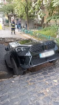 UPDATE - O maşină a căzut într-o groapă formată în asfalt, în Sectorul 6 / Incidentul, la trecerea unui utilaj de salubrizare / O femeie şi copilul ei de 5 ani, lângă maşină / Au refuzat transportul la spital / Reacţia Primăriei - FOTO