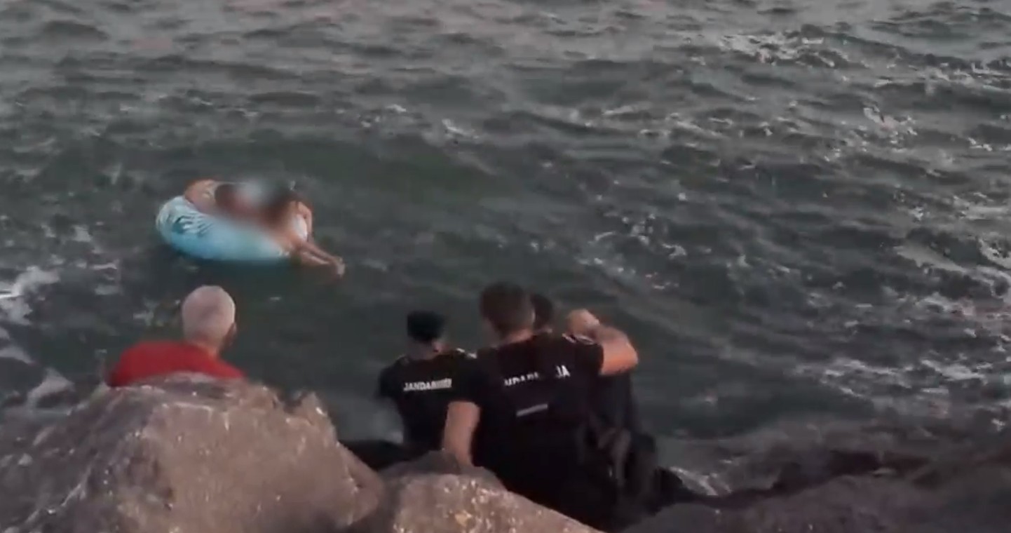 Două persoane care se aflau pe un colac şi care fuseseră luate de curenţi, în apropierea unei plaje din Constanţa, ajutate de jandarmi să ajungă la mal - VIDEO