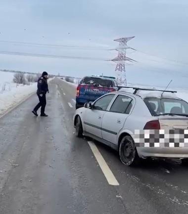 Dolj: Intervenţie a jandarmilor pentru deblocarea unui autoturism care a derapat şi a rămas în zăpadă - VIDEO