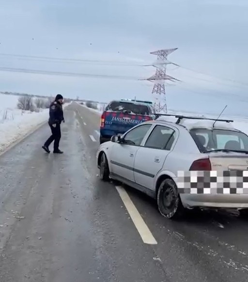 Dolj: Intervenţie a jandarmilor pentru deblocarea unui autoturism care a derapat şi a rămas în zăpadă - VIDEO

