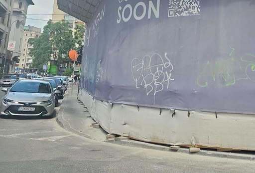 Trei tineri, prinşi în flagrant când mâzgăleau cu graffiti pe plasa de protecţie a unui hotel aflat în construcţie în Bucureşti – Unul dintre ei a vrut să fugă, fiind urmărit de un poliţist local – A intervenit şi Brigada Rutieră - FOTO