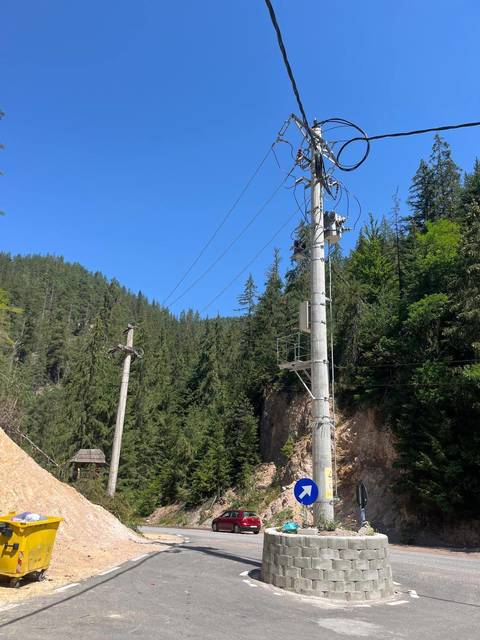 Un stâlp a fost lăsat în mijlocul unui drum comunal din judeţul Alba, după reabilitarea şoselei / Pentru a masca eroarea, constructorul a ”inventat” un sens giratoriu, deşi în zonă nu este intersecţie - FOTO