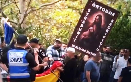 Susţinători ai lui Călin  Georgescu, la sediul DIICOT/ Autorităţile au montat garduri de protecţie/ Echipaje de jandarmi în zonă/ Unul dintre susţinători, cu un baston telescopic, escortat de jandarmi pe partea cealaltă a drumului