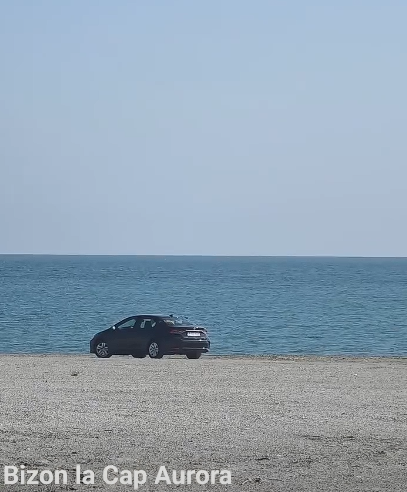 Autoturism înmatriculat în Bucureşti, filmat pe plajă, la Cap Aurora. Mesaj ironic la adresa şoferului: „«Sânt ân faţă pe avari». Pe plajă la Cap Aurora, mai exact”
