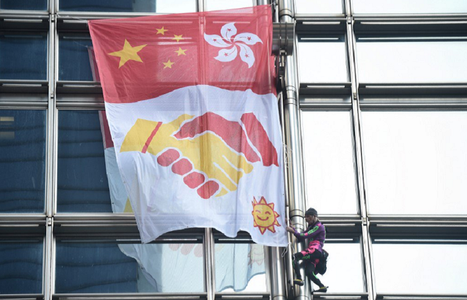 "Spiderman"-ul francez Alain Robert desfăşoară o banderolă a păcii pe un zgârie-nori la Hong Kong