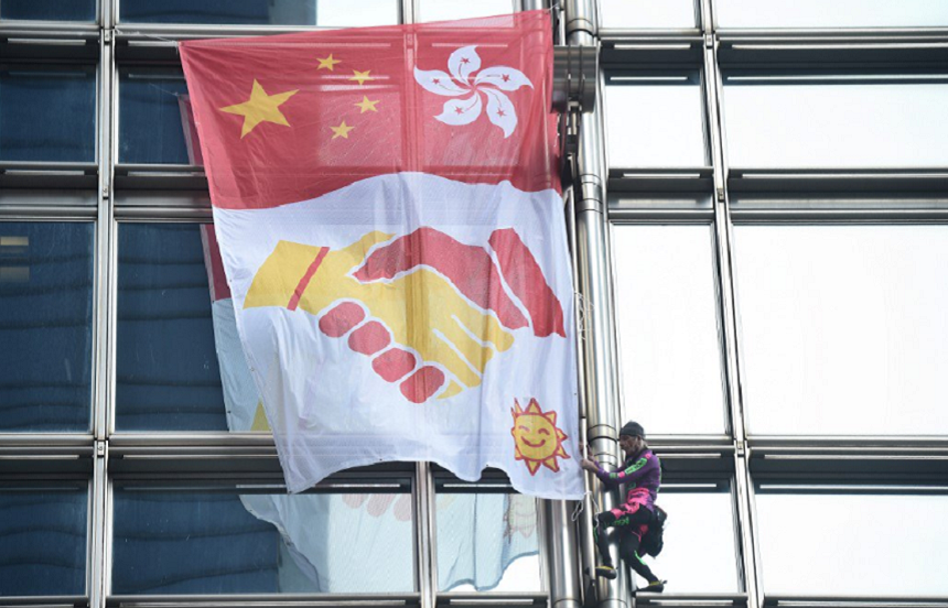 "Spiderman"-ul francez Alain Robert desfăşoară o banderolă a păcii pe un zgârie-nori la Hong Kong