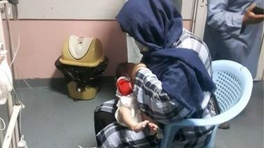 O femeie alăptează copiii mamelor ucise în atacul comis asupra unei maternităţi din Kabul

