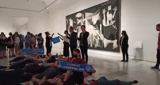 Protest al activiştilor anti-război în faţa picturii Guernica a lui Pablo Picasso din Muzeul Naţional Regina Sofia, din Madrid: Protestatarii, întinşi pe podea, imită poziţia unui cadavru - VIDEO
