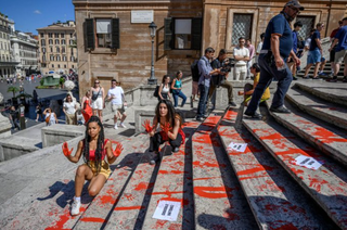 Activiste feministe italience din organizaţia ”Bruciamo tutto”, care luptă împotriva feminicidului, stropesc cu sânge fals în Piaţa Spania, la Roma