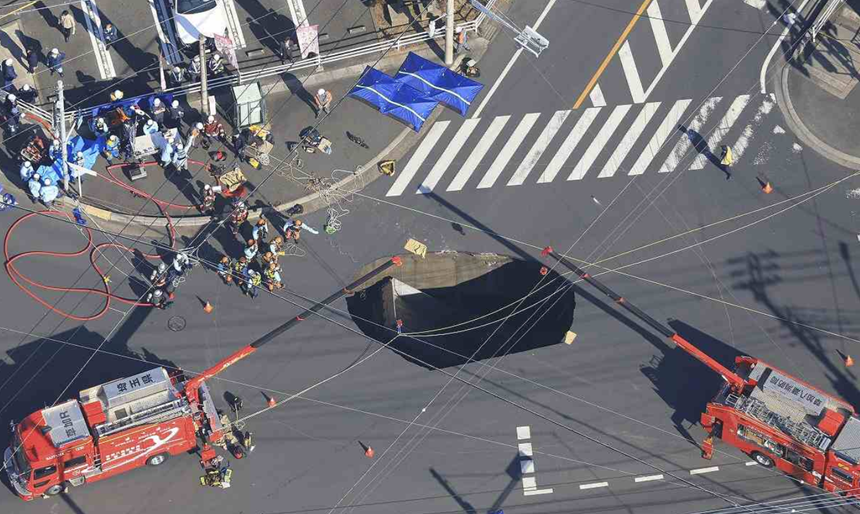 Un camion cade într-o gaură căscată în asfalt în Japonia, la Yashio, în apropiere de Tokyo. Salvatori încearcă să salveze şoferul în zadar. Operaţiuni de intervenţie