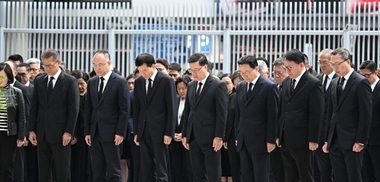 Şeful Executivului din Hong Kong şi miniştri păstrează un moment de reculegere în faţa sediului Guvernului local, după incendiul soldat cu 128 de morţi. Steagurile, coborâte în bernă