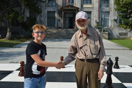 Vaslui: Cel mai în vârstă şahist legitimat din România, partidă demonstrativă la 85 de ani cu un elev de 10 ani, pe cea mai mare tablă de şah din ţară FOTO
