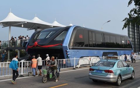 Un nou sistem de transport în comun, testat în China. Autobuzul electric permite circulaţia maşinilor pe sub el şi poate transporta 300 de călători. FOTO, VIDEO