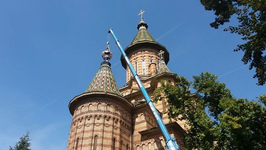 O cruce ornamentală a fost montată pe unul dintre turnurile Catedralei Mitropolitane din Timişoara, după ce vechea cruce a căzut în timpul furtunii puternice de anul trecut. FOTO