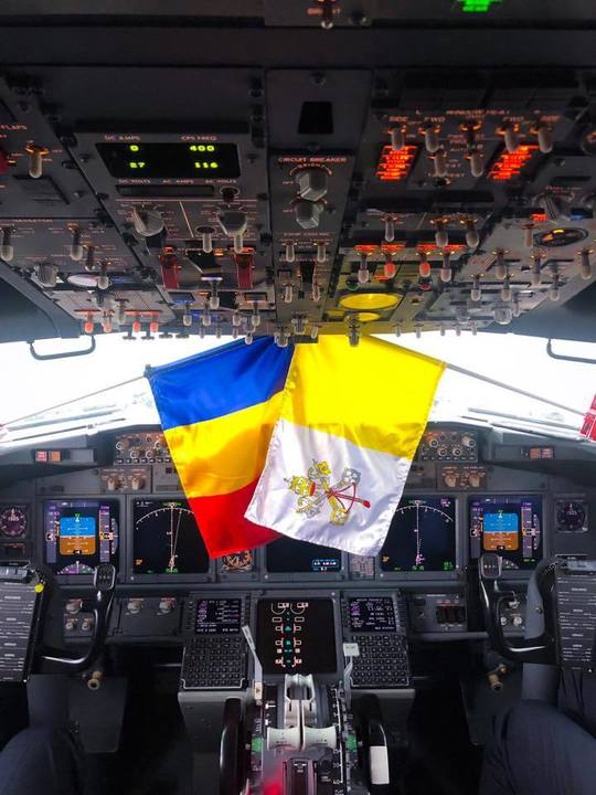 Steagul României şi cel al Vaticanului, în cabina piloţilor înainte de zborul Papei către Roma. FOTO: Tarom