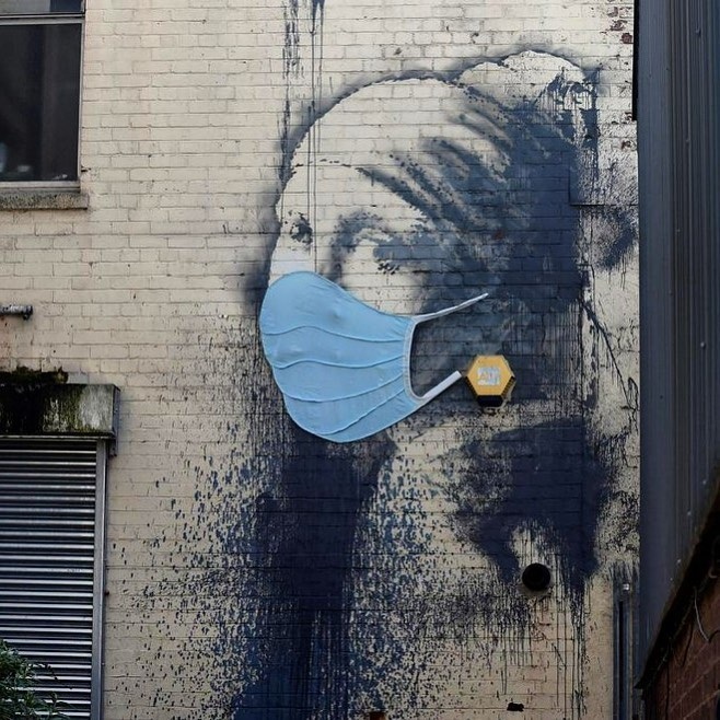 Lucrarea murală a lui Banksy "Girl with a Pierced Eardrum" a primit o mască de protecţie