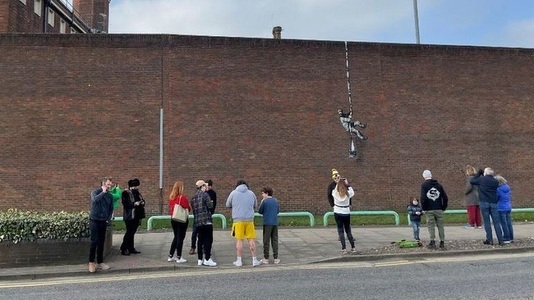 O lucrare similară celor semnate Banksy, pe zidul unei foste închisori din Anglia