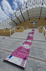 Un artist portughez a întins un covor de bancnote în semn de protest faţă de costurile vizitei papei Francisc la Lisabona 