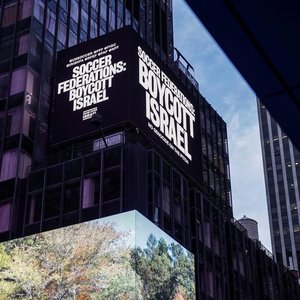 Mesaj prin care se cere boicotarea echipei Israelului, afişat în Times Square, înainte de Cupa Modială de anul viitor. "În sport nu este loc pentru criminalii de război"