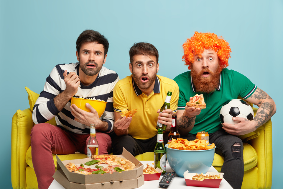 //i0.1616.ro/media/581/3142/38107/21326424/1/excited-three-male-friends-watch-sport-tournament-have-bated-breath-during-dangerous-moment-bite-crisps-popcorn-pizza-sit-yellow-sofa-living-room-soccer-fans-with-beer-football-supporter.jpg